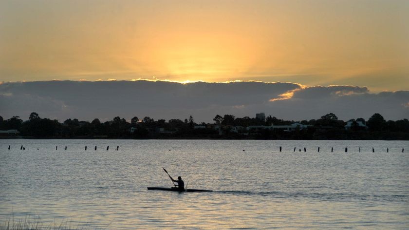 A kayaker paddles at sunset