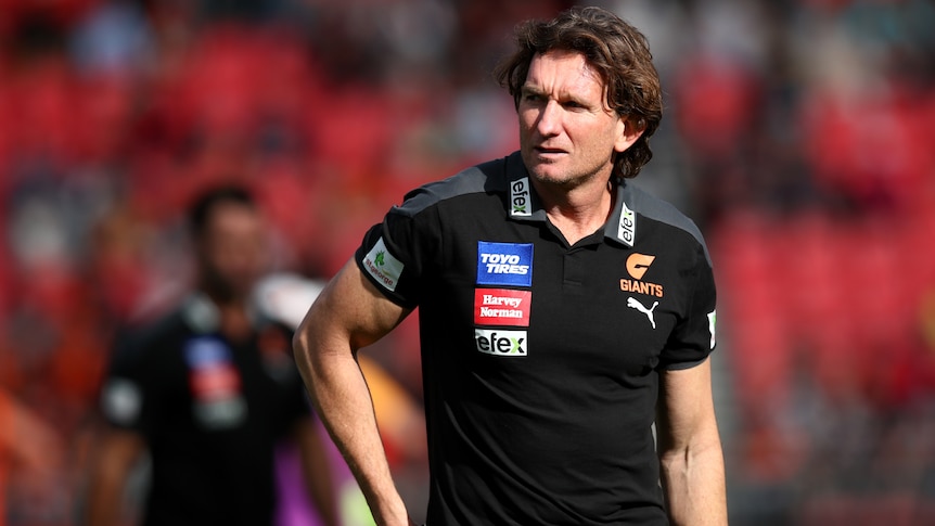 James Hird wearing a GWS Giants AFL polo shirt during a match in 2022.