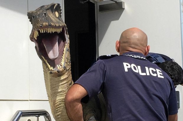 police carry the dinosaur inside the building