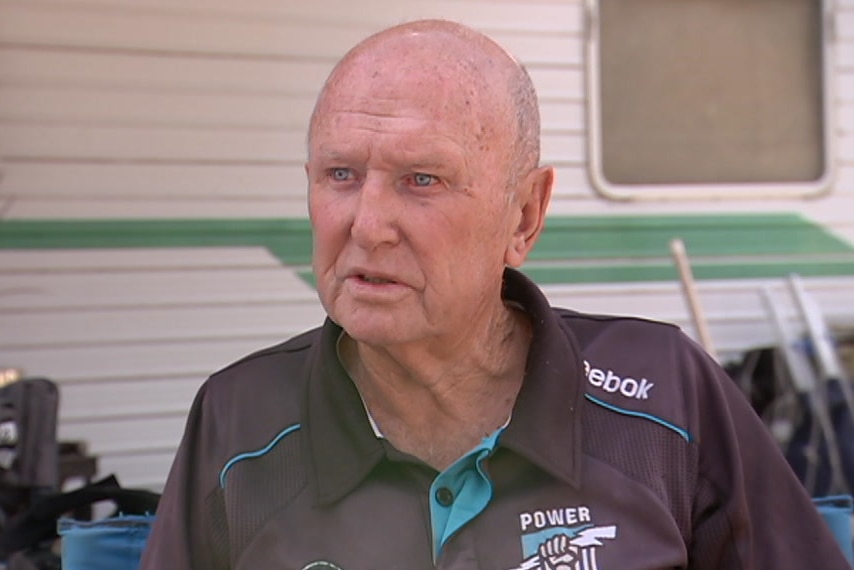 A man sitting in front of a caravan