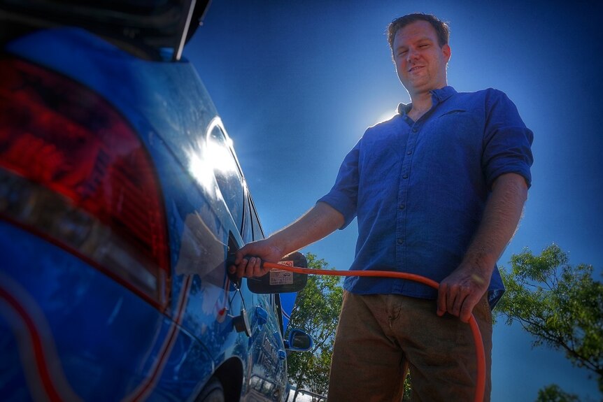 Wiebe Wakker charges the electric car he drove to Australia from Holland.