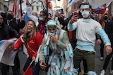 People wearing face masks on their body dance during a demonstration against the closure of the nightclubs