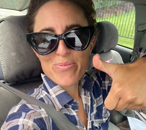 a woman in sunglasses waiting in a car