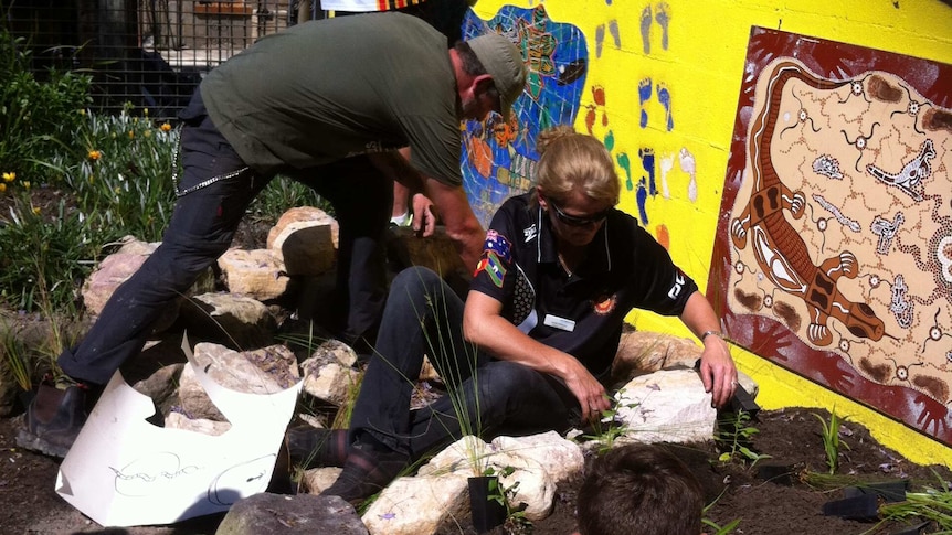 The Aboriginal garden with a bright yellow wall filled with colourful footprints and animals.