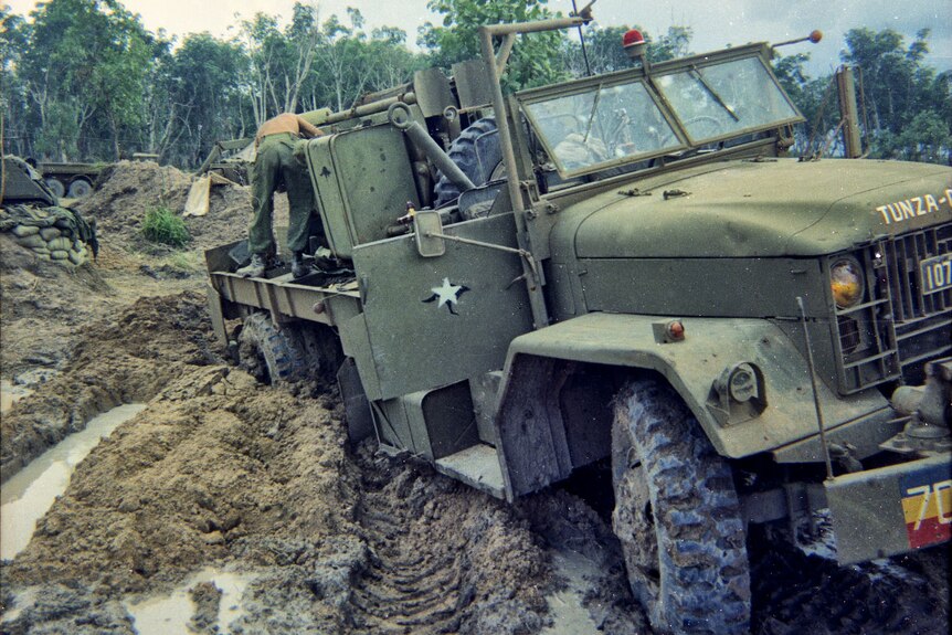 An army vehicle is stuck in thick mud.