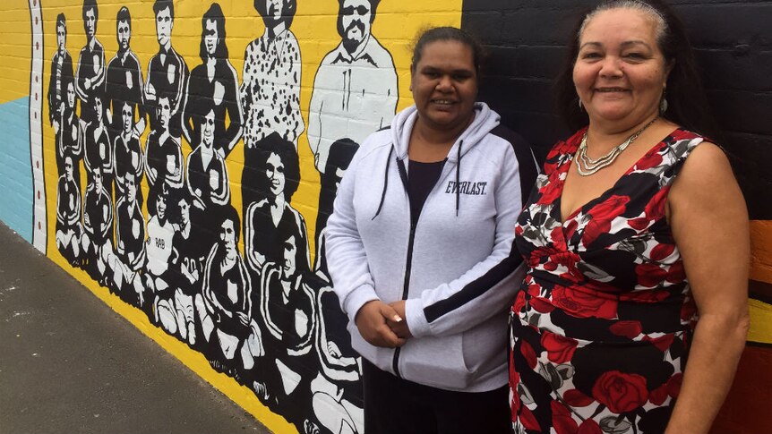 Margaret Miles and Donna Ingram stand in front of the Redfern mural.