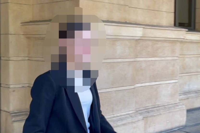 A woman outside a court building, her face is blurred
