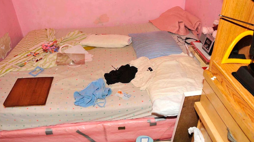Clothes and objects sit on a bed in a room in Ariel Castro's house