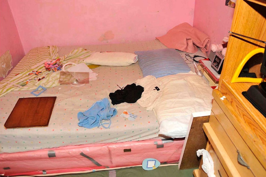 Clothes and objects sit on a bed in a room in Ariel Castro's house