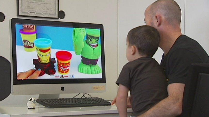 Father and son watch an unboxing video