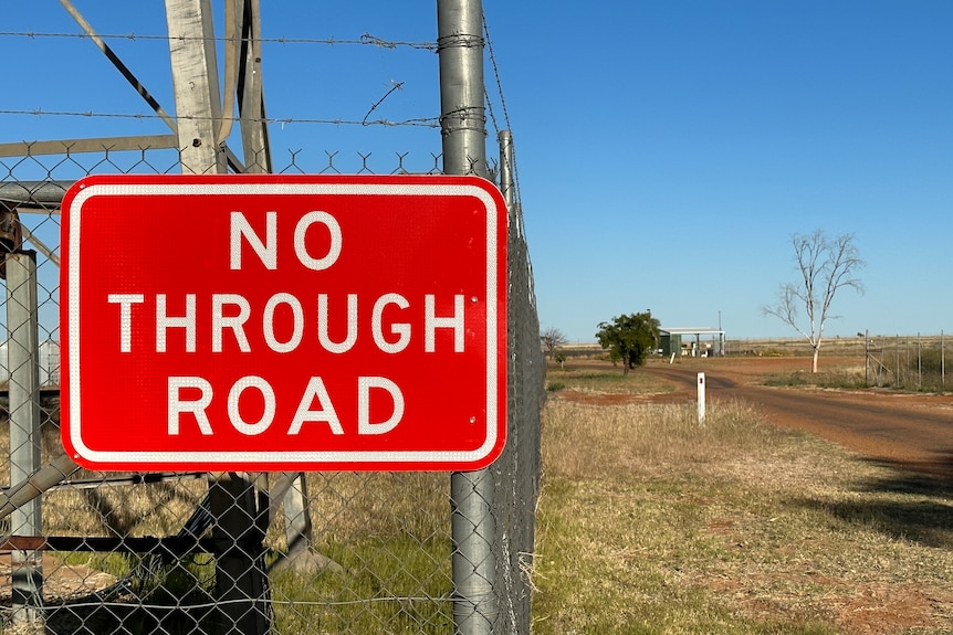 'No through road' sign with gravel road on the right.