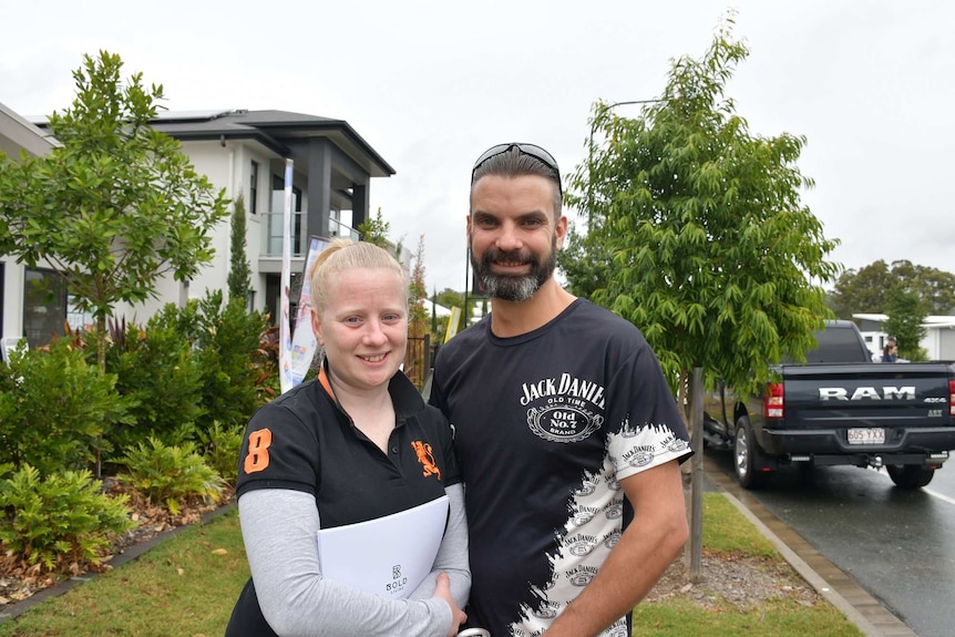 Troy and Alana Simons stand in a street smiling at the camera.