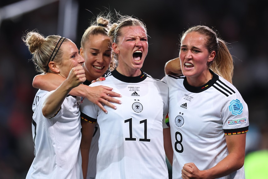 Alexandra Popp celebrates and is mobbed by teammates after scoring the deciding goal in the Euro semi-finals