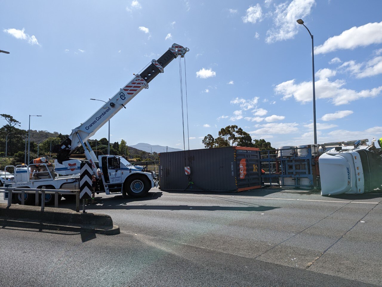 Truck driver rescued after bridge rollover leads to major traffic