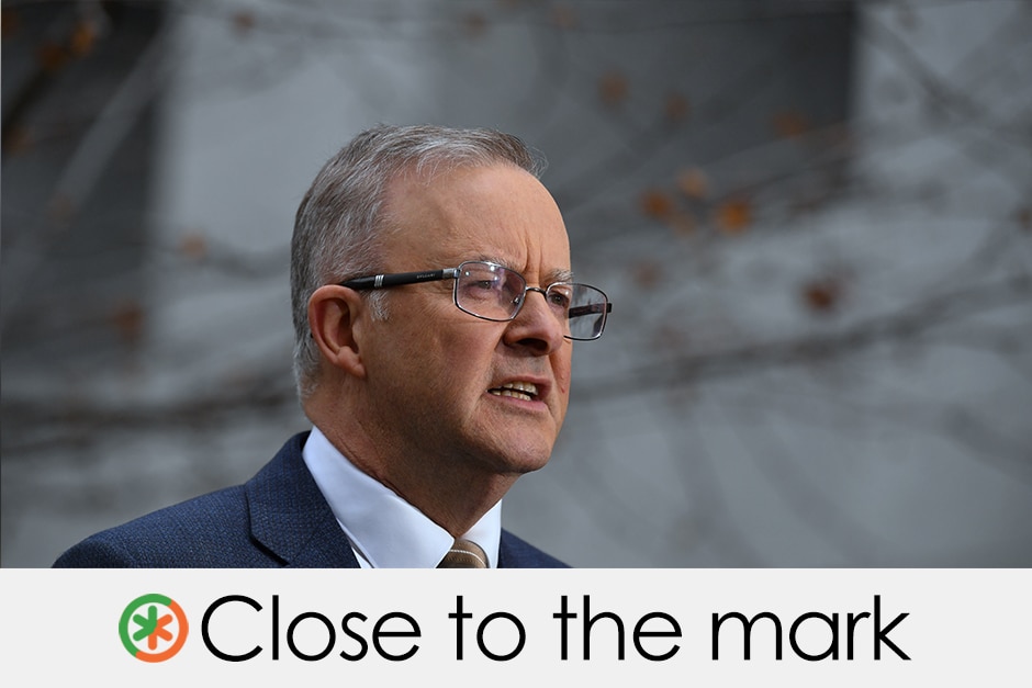 A 60-something man in business suit looks into the distance in outdoor setting.