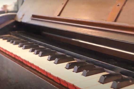 A close-up of the keys of an old pedal organ