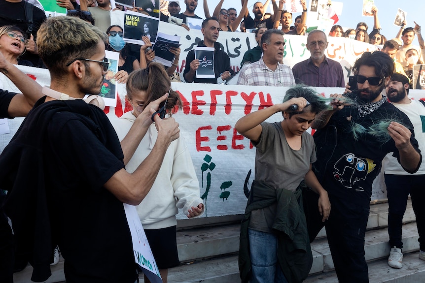 Women have their hair during a protest against the death of Iranian Mahsa Amini.