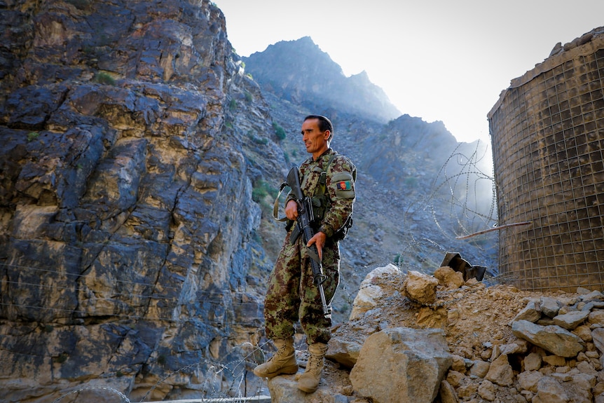 A man in combat gear stands 