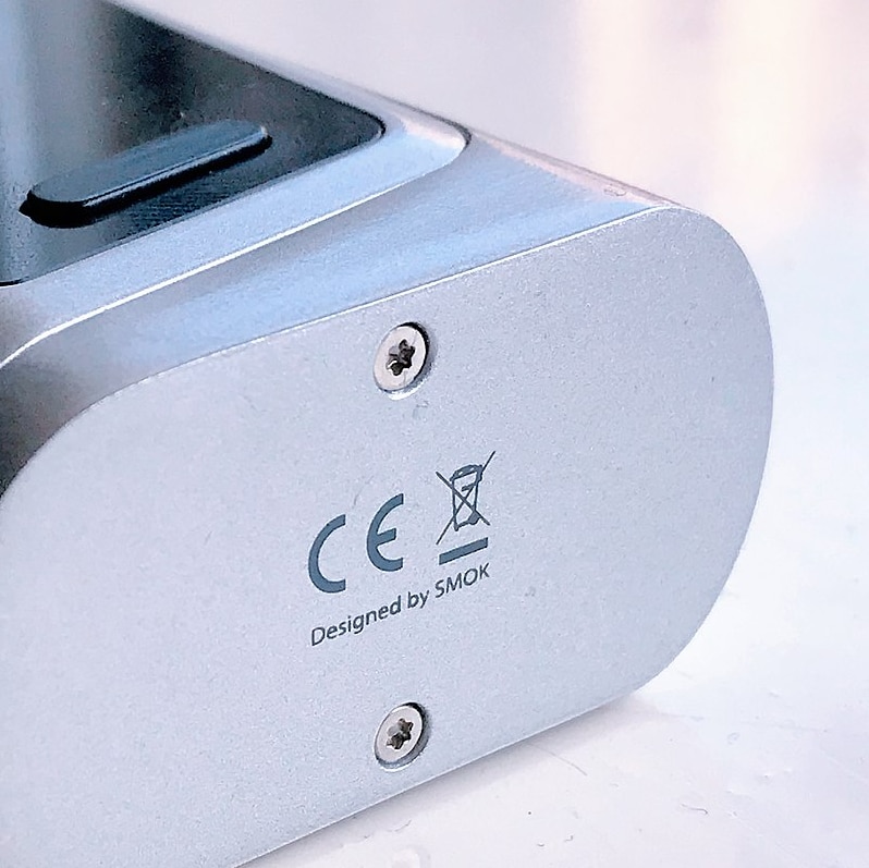 The bottom of a silver device that carries the "CE" logo and a "do not dispose" logo.