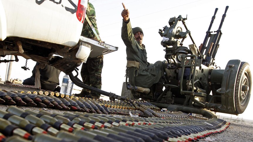 A Libyan rebel sits on an anti-aircraft gun
