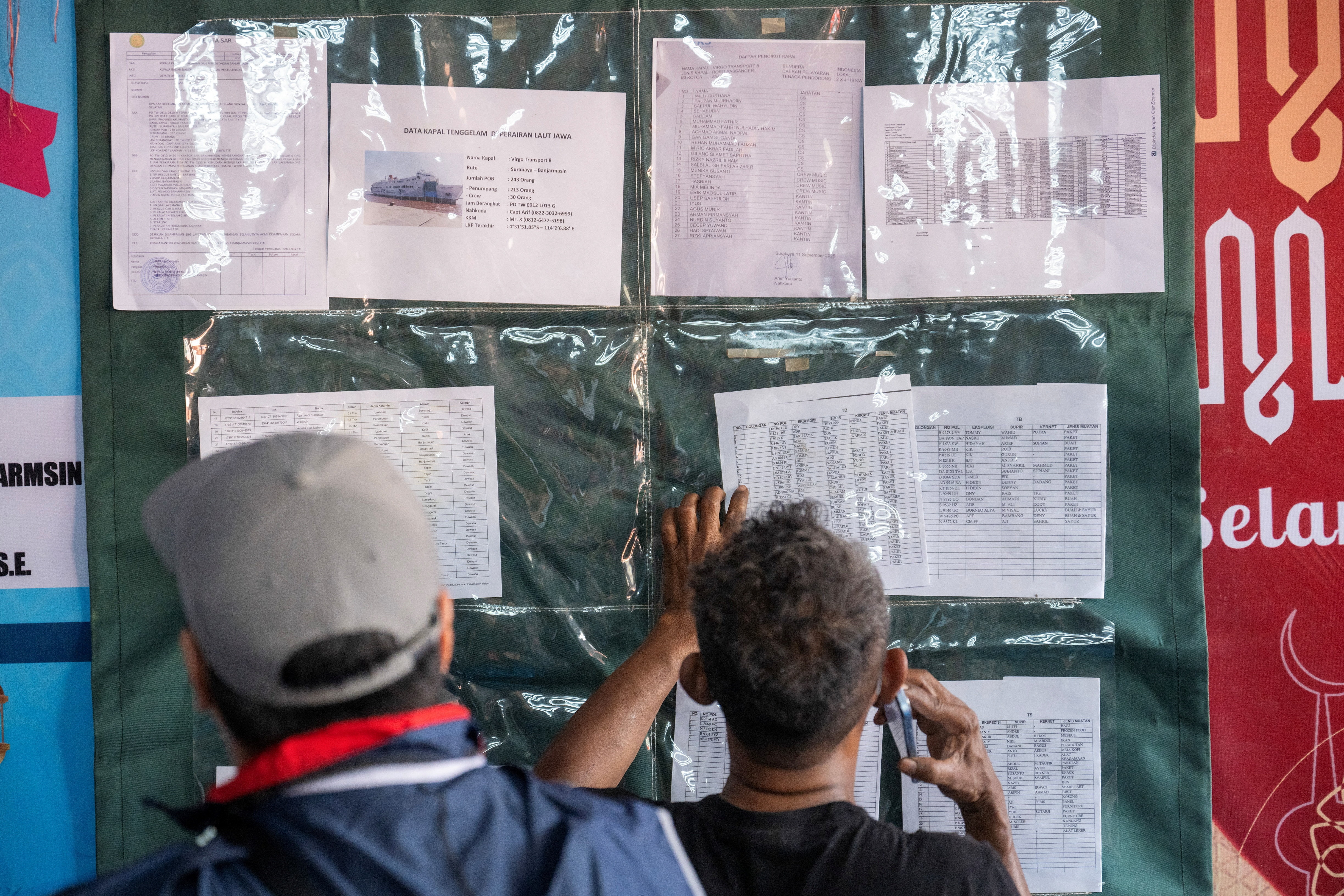 A wall with papers displaying names and other details of passengers.