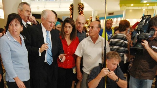 A woman was knocked over by the media scrum surrounding John Howard.