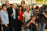 A woman was knocked over by the media scrum surrounding John Howard.