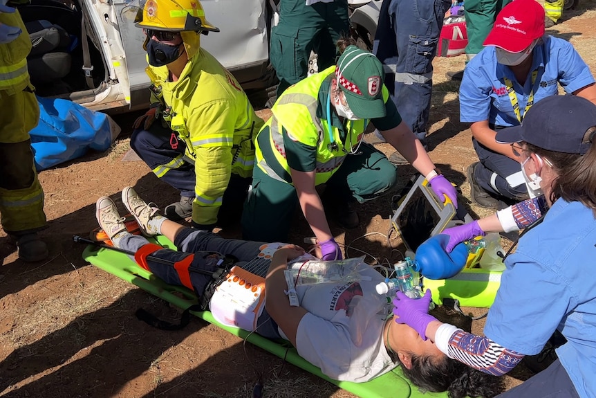 A person on the stretcher is treated by a medical team.