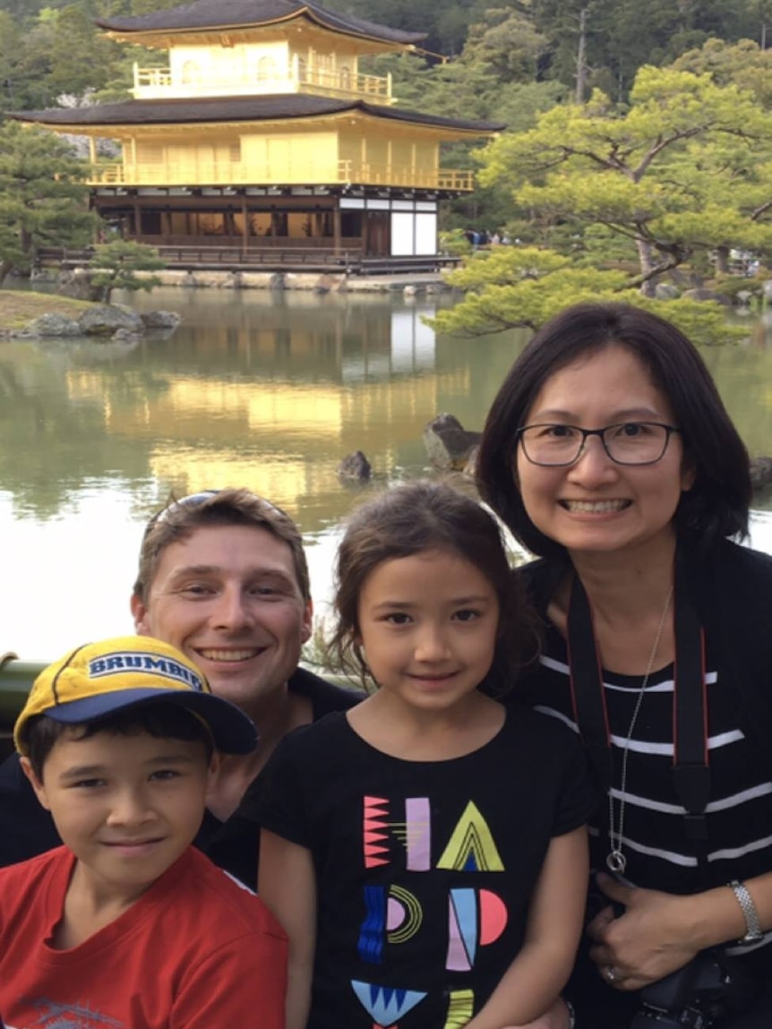 A family pose in front of a temple