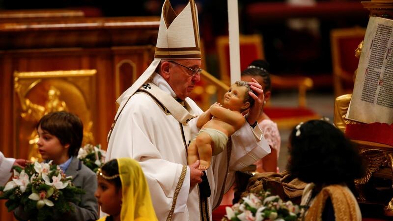 Pope Francis holds a statuette of baby Jesus