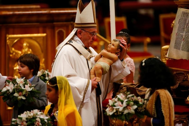 Pope Francis holds a statuette of baby Jesus