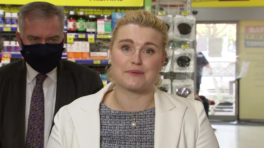 A blonde woman wearing a white jacket