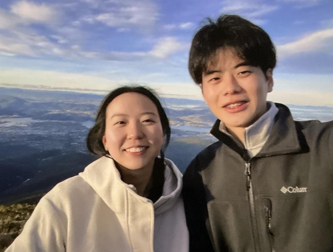 A selfie of Leannedra Kang and Takahiro Toya with a view of Hobart below them