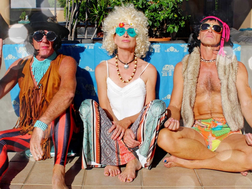 Andrew, Lisa and Carl dressed in hippie outfits, including wigs, sunglasses and fringed clothing