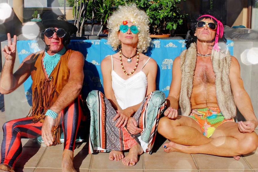 Andrew, Lisa and Carl dressed in hippie outfits, including wigs, sunglasses and fringed clothing