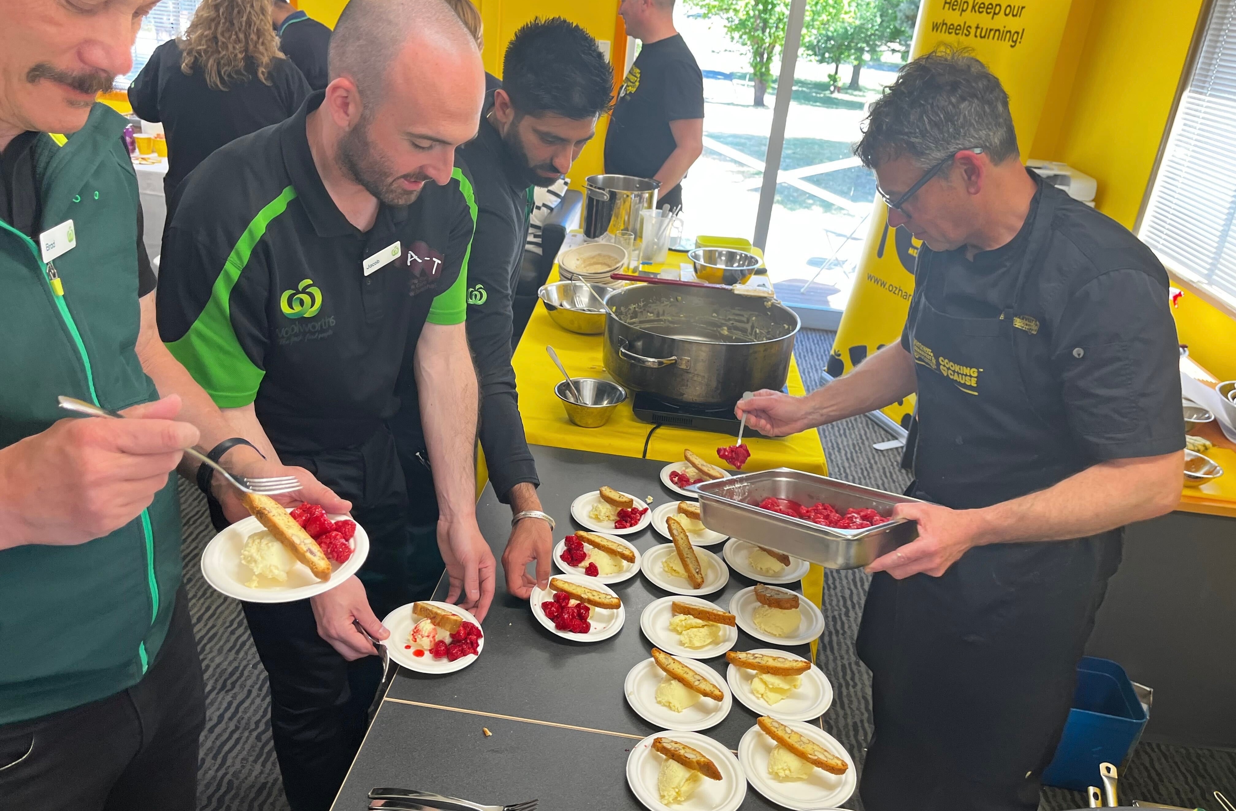 A group of people help themselves to servings of a communal meal.
