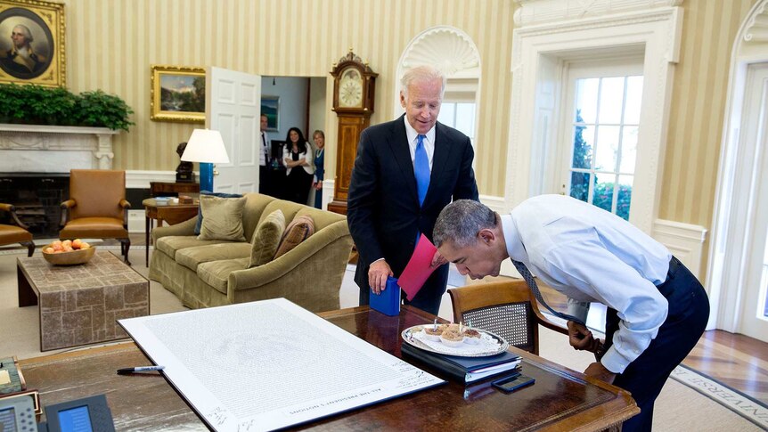 President Barack Obama blows out candles
