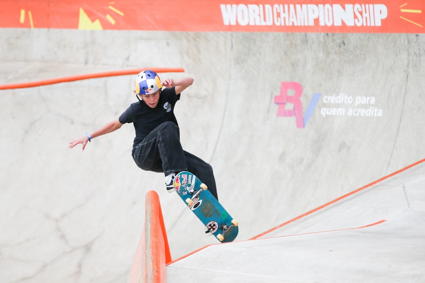 A man wearing black pants and a black shirt on a skateboard