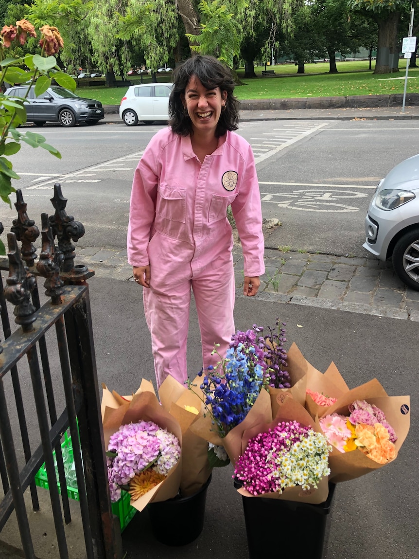 Emely Alakus standing above bunches of flowers