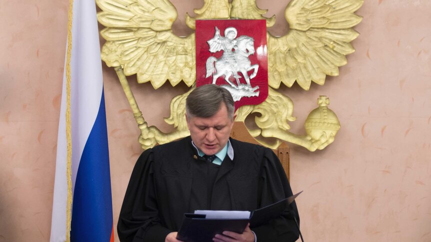 Russia's Supreme Court judge Yuri Ivanenko reads the decision in a court room.