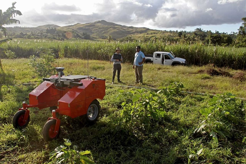 Farm Robot in the field with Fijian farmer and one of the project engineers