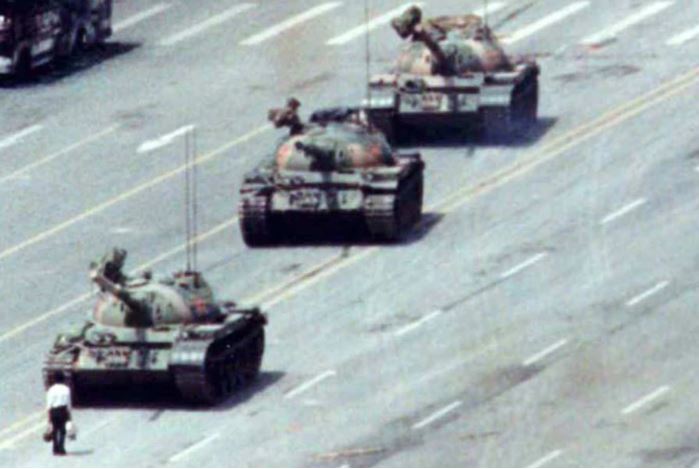 A man stands in front of a tank near Tiananmen Square.