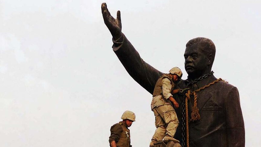 US marines climb to topple the statue of Saddam Hussein in Baghdad
