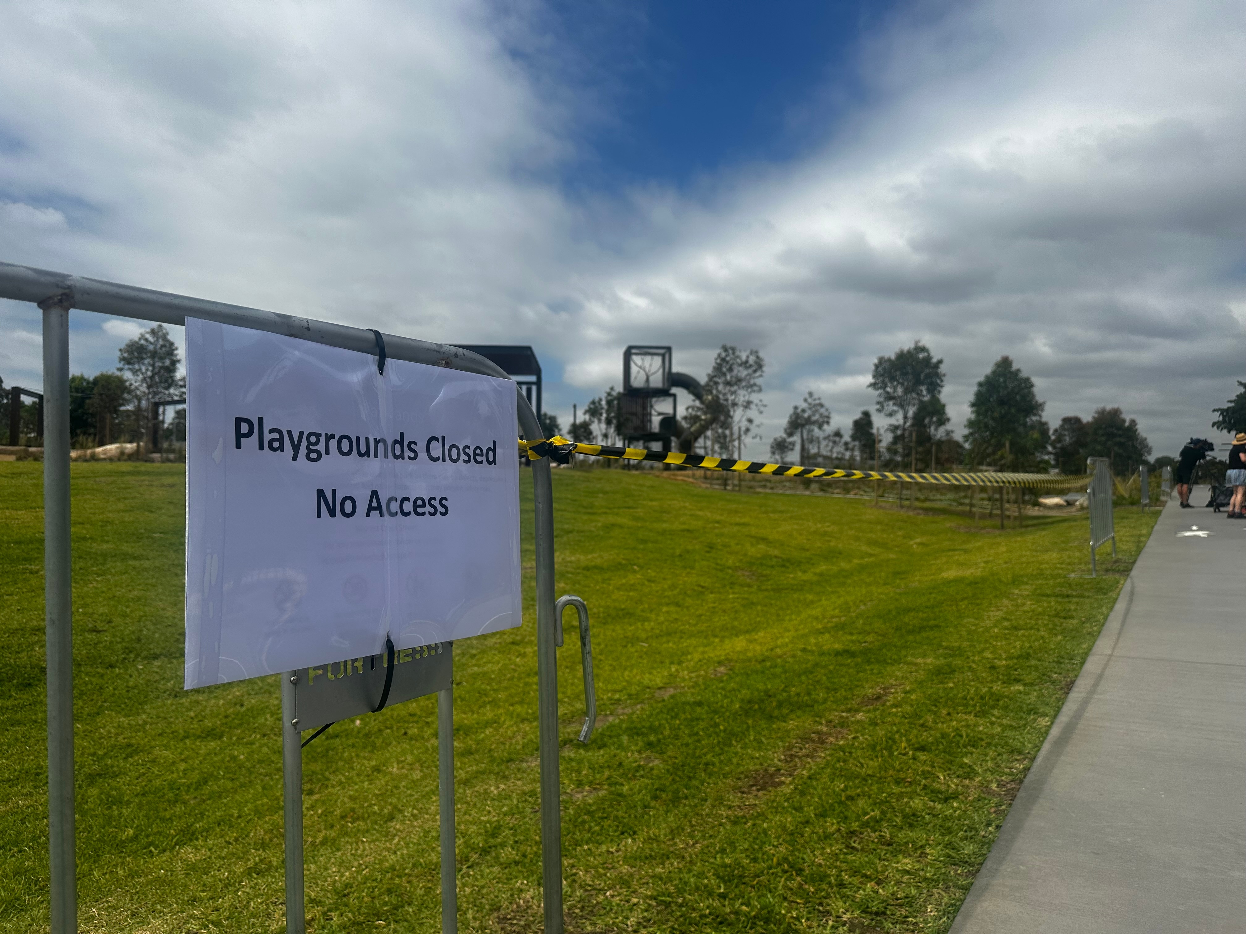 Park grass cordoned off with tape and signs