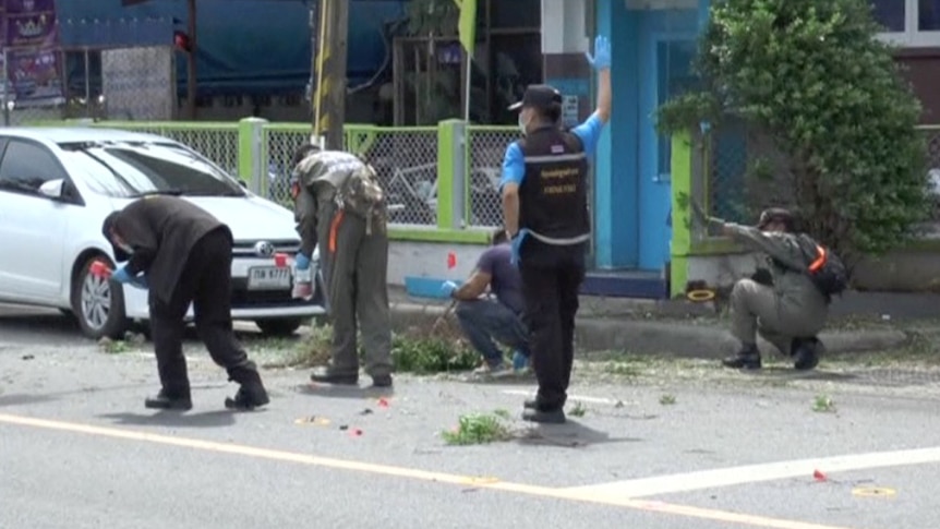 Police check the scene after two bomb blasts in Surat Thani