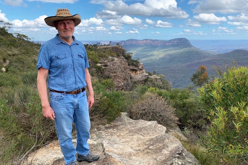 Ross Bradstock stands at the top of a cliff.