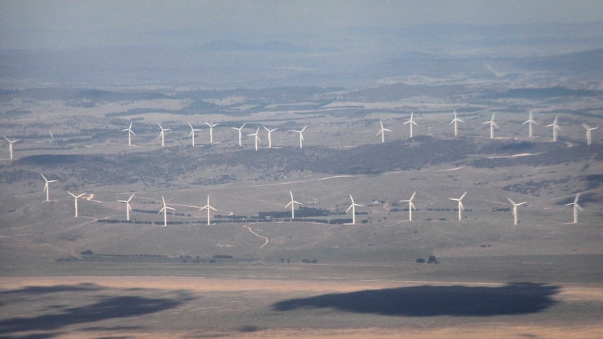 Aerial photo of wind turbines next to an empty Lake George, with the landscape disappearing into the distance.