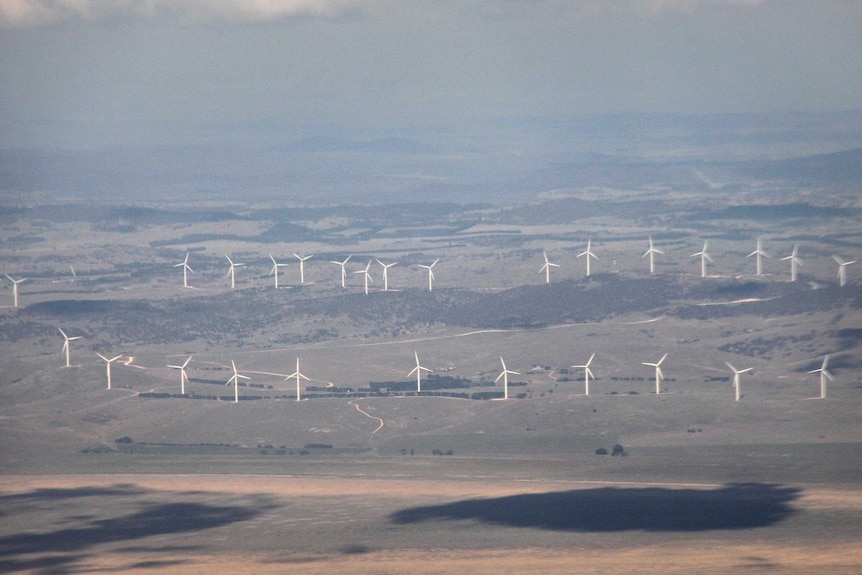 Aerial photo of wind turbines next to an empty Lake George, with the landscape disappearing into the distance.