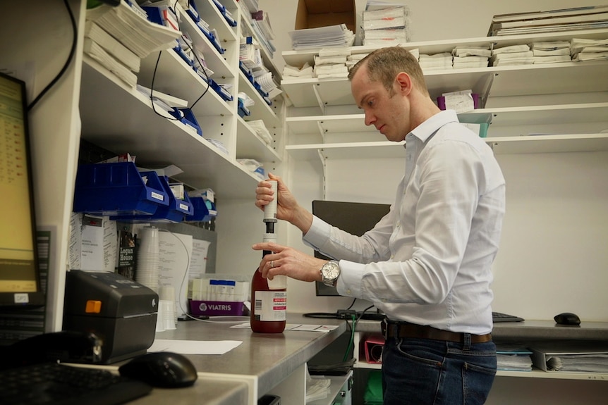 Pharmacist Andrew Pfeffer pours Aspen Methadone Syrup into a cup
