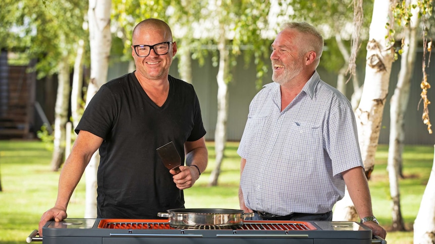 Celebrity chef Heston Blumenthal stands in front of a barbeque with Murray Cod Australia chairman Ross Anderson.